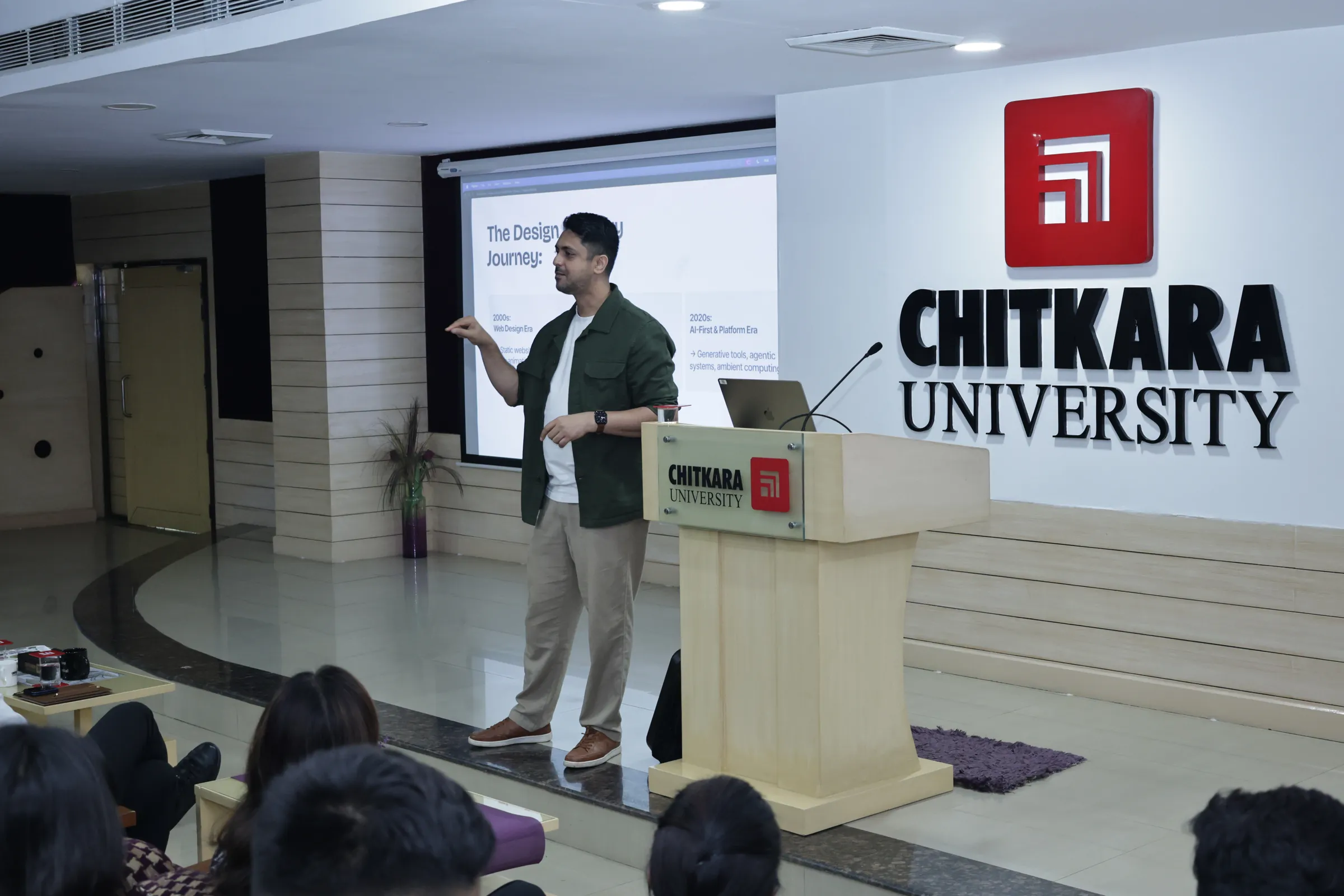 Ameet Palkar presenting beside a lectern at Chitkara University, a slide about the design journey behind him