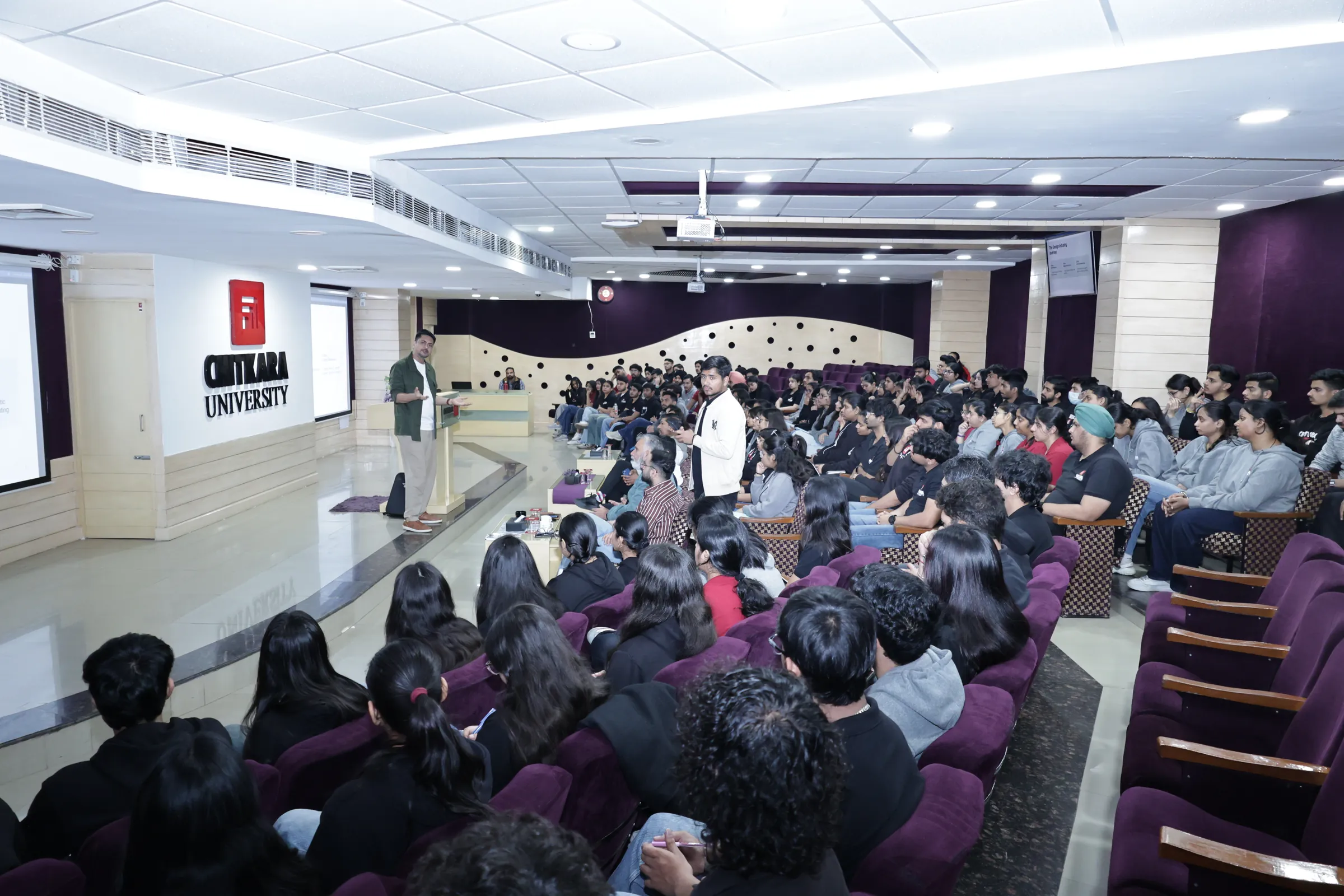 Students filling the lecture hall during the master class, one standing to ask a question