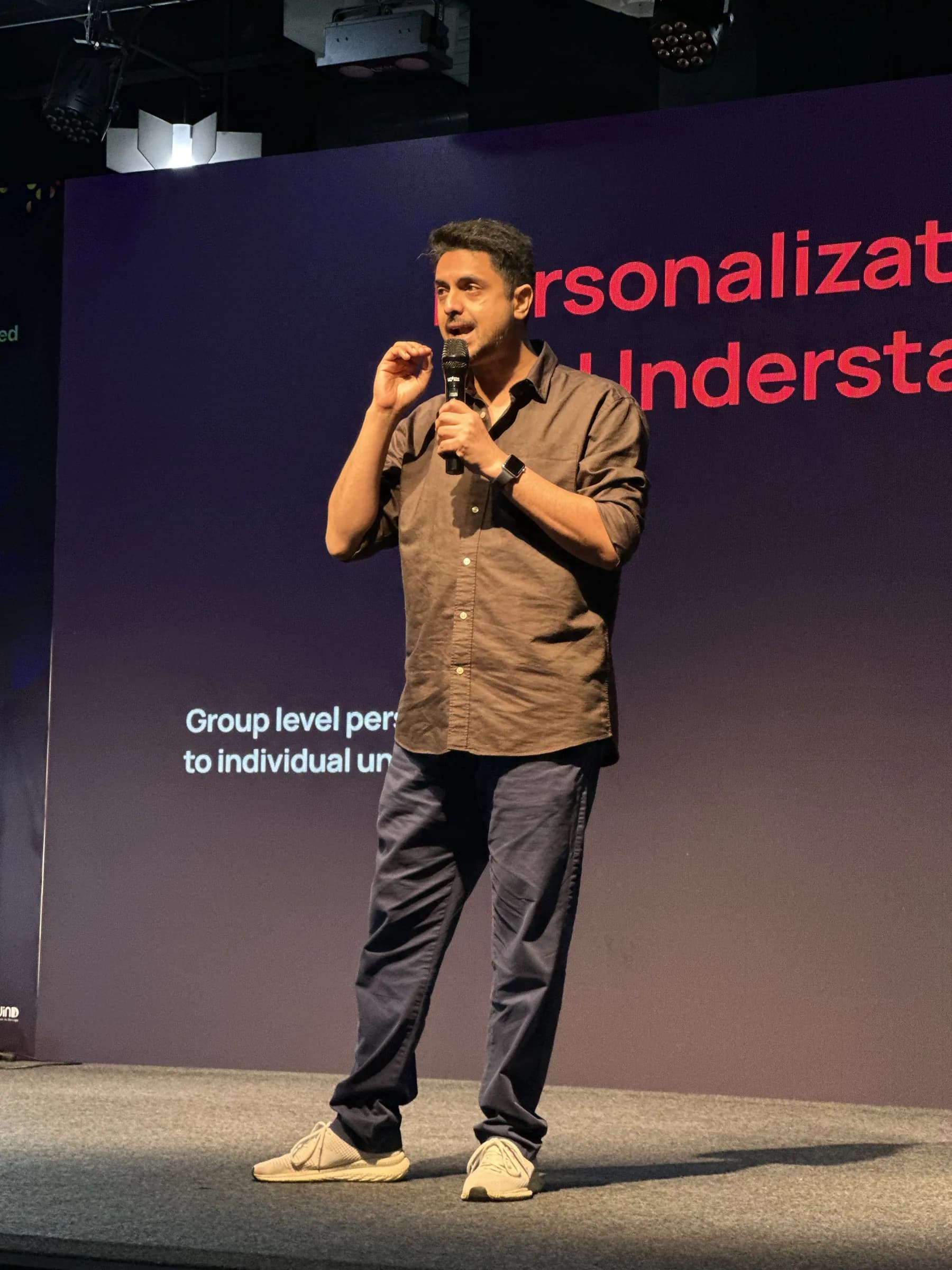 Ameet speaking into a microphone on stage