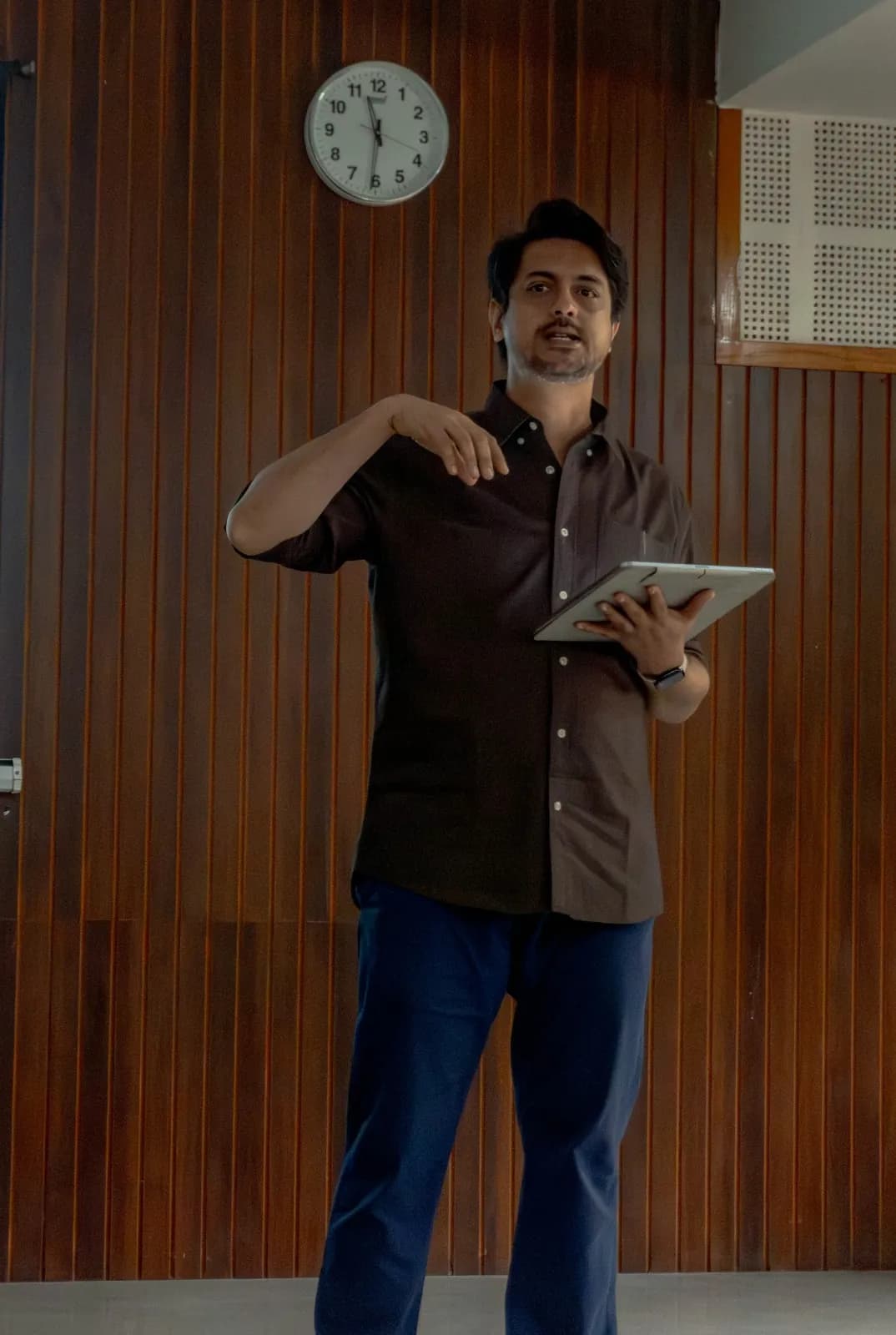 Ameet mid-explanation, holding a tablet